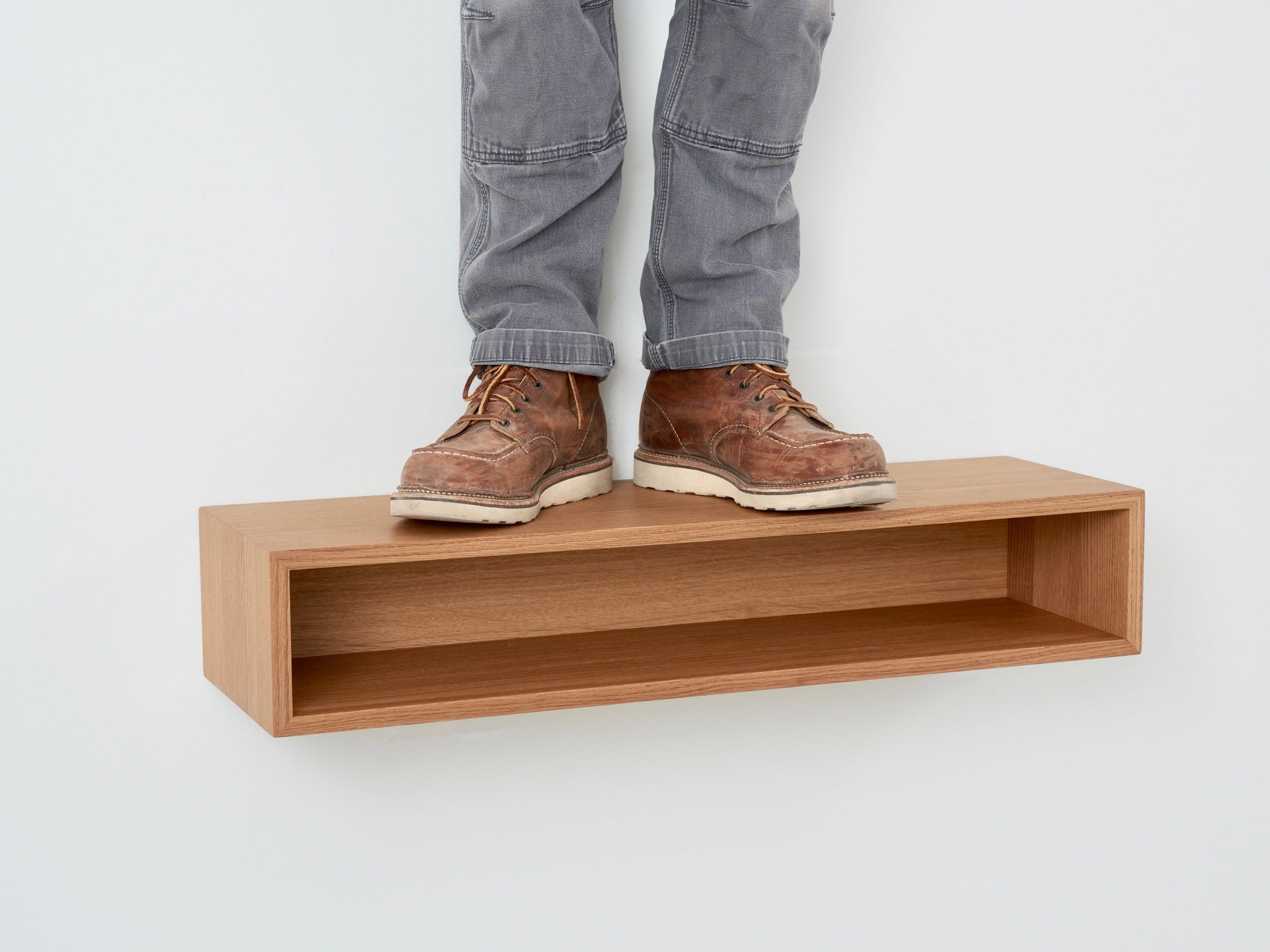 A person's legs on a shelf.