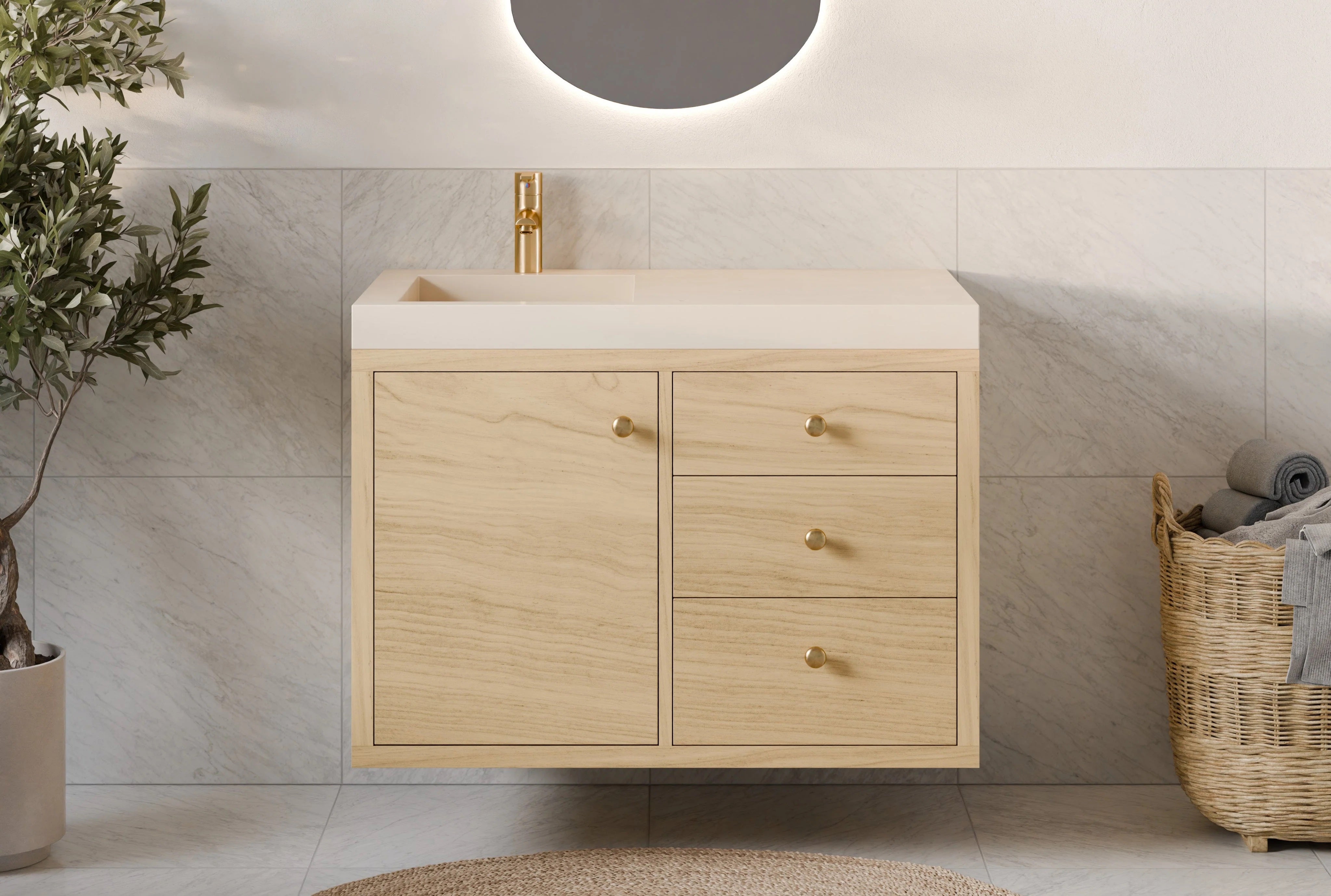 A modern bathroom showcases a Krovel Furniture Co. Single Door, Triple Drawer Vanity in Maple, complemented by a gold faucet and an oval mirror with soft backlighting