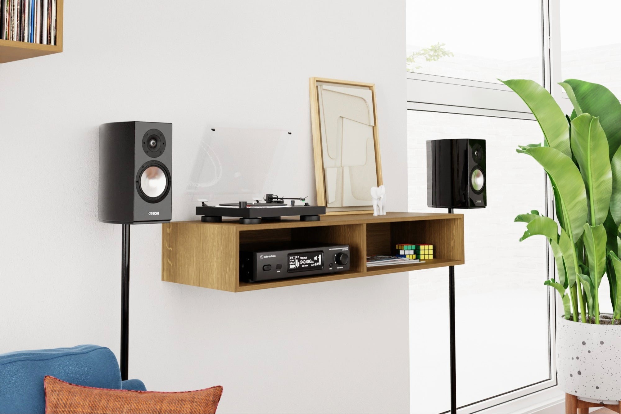 A cozy living room with a wooden shelf holding a turntable, speakers, and a framed abstract art piece. A potted plant sits nearby, adding a touch of greenery to the minimalist space.