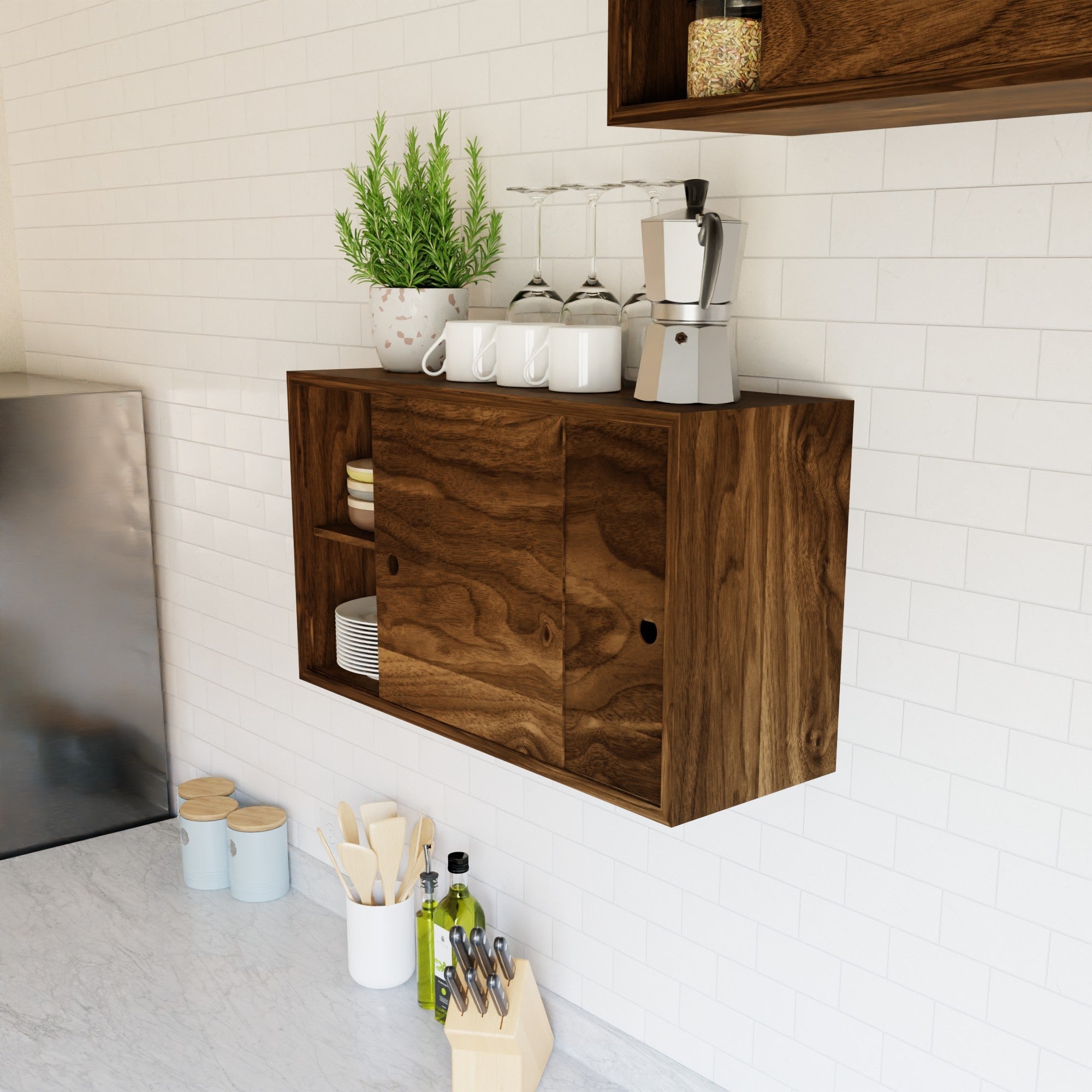 A modern kitchen with a wooden wall cabinet holding dishes, a plant, a coffee maker, and glasses. Below, a marble countertop has utensils, olive oil, and a knife block.