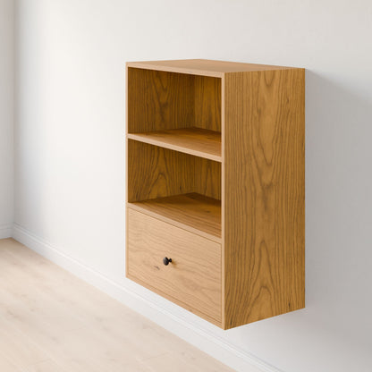 The Krovel Furniture Co.'s Closet Drawers and Shelves in Cherry is a wooden wall-mounted unit made from premium plywood. It features two open compartments and a solid drawer at the bottom. The natural wood grain pattern complements the light-colored wall and pale hardwood floor beneath it. 