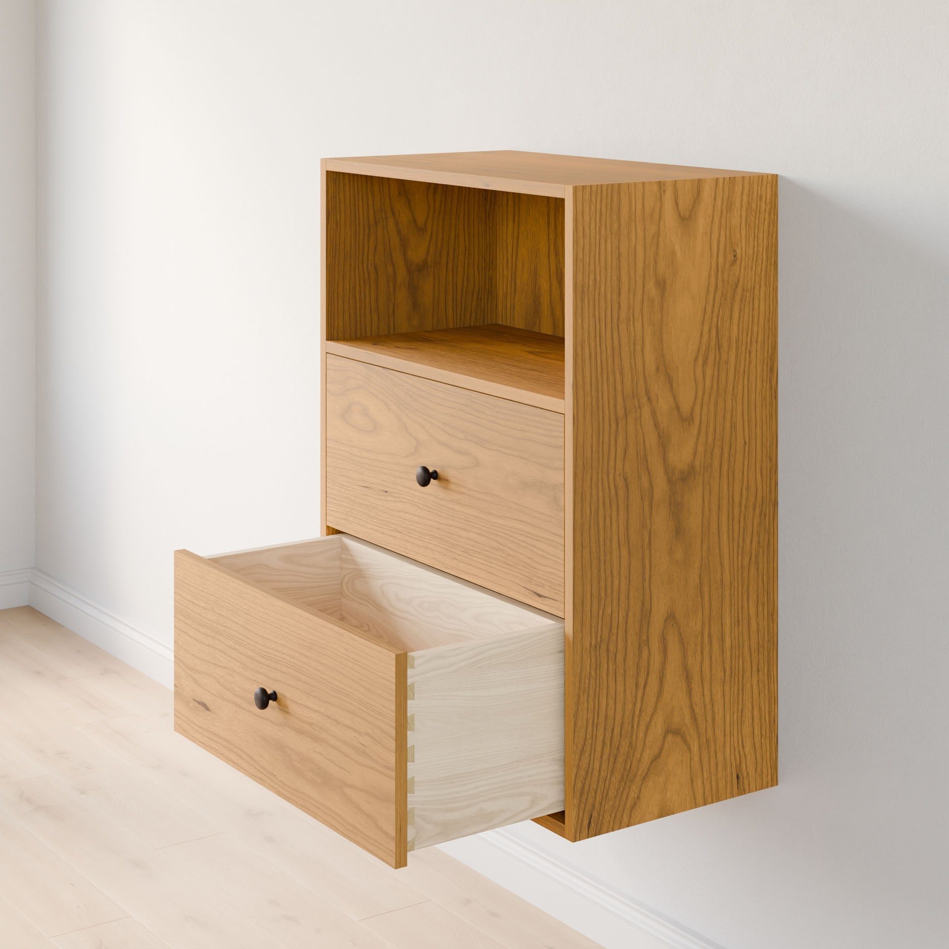 The Krovel Furniture Co. Closet Drawers and Shelves in Cherry is a wooden wall-mounted cabinet made of premium-grade plywood, boasting a simple design with solid Maple drawers. The top drawer is closed, the bottom open, revealing a light wood interior against a light-colored wall and floor. 