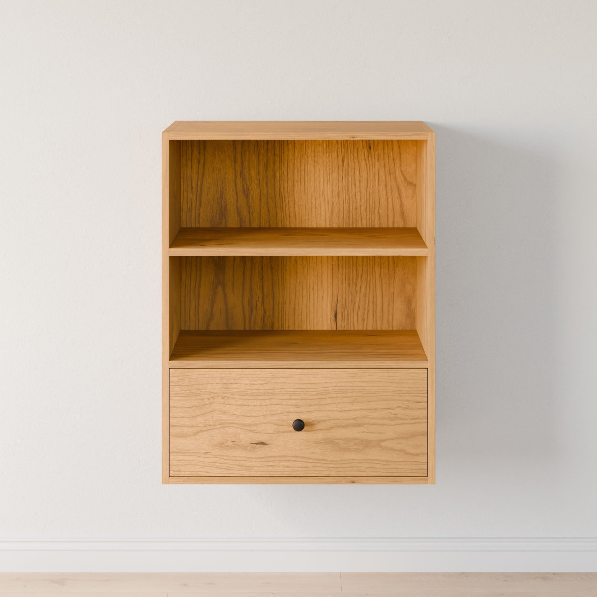 A small, wall-mounted shelf by Krovel Furniture Co., crafted from premium plywood, features two open compartments and a solid Maple drawer with a light finish and black knob, set against a plain white wall. #configuration_double-shelf-single-drawer