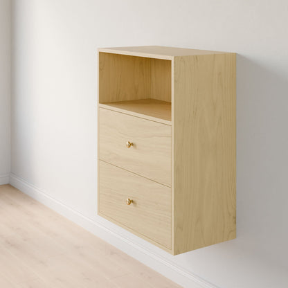 The Closet Drawers and Shelves in Maple by Krovel Furniture Co. is a wooden, wall-mounted cabinet crafted from premium-grade plywood on a light-colored wall, featuring one open modular shelf on top and two drawers with small round knob handles below. A light wood floor beautifully complements its natural finish. 