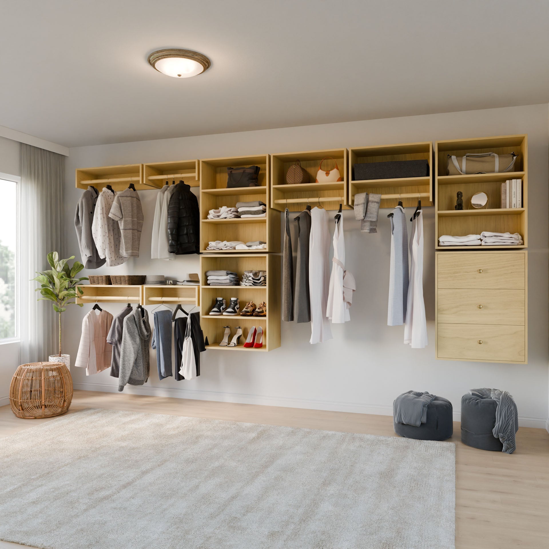 The Krovel Furniture Co. Closet Drawers and Shelves in Maple create a spacious walk-in closet with clothes, shoes, and accessories displayed. A large window with curtains invites natural light. Two woven baskets, a houseplant, and a ceiling light complete the space. 