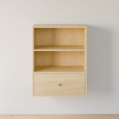 The Krovel Furniture Co. "Closet Drawers and Shelves in Maple" is a minimalist, wood wall-mounted shelf with dovetail construction for durability. It features two open compartments, one drawer with round knob, and rests against a white wall and light hardwood floor, highlighting its natural grain and clean lines. 