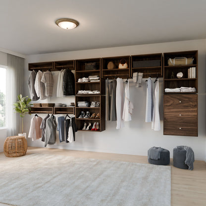 A minimalist bedroom features a built-in open wardrobe from Krovel Furniture Co. with Closet Drawers and Shelves in Walnut, showcasing neatly organized clothes, shoes, and bags. A light gray rug adorns the wooden floor, while a round wicker basket sits by the window with sheer curtains. 