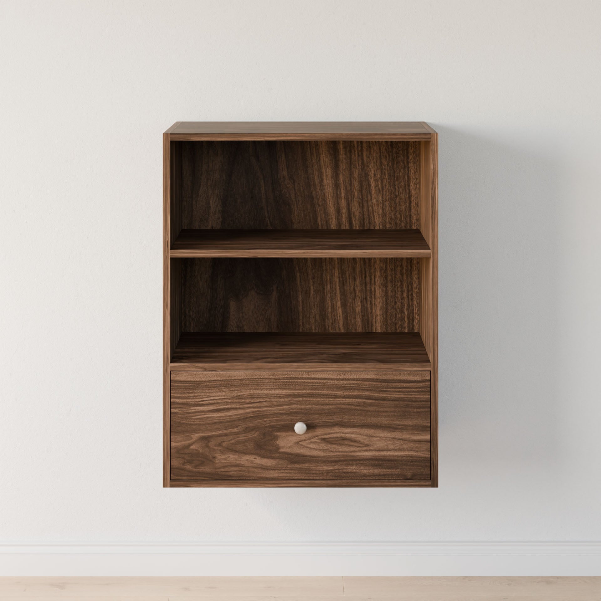 The "Closet Drawers and Shelves in Walnut" by Krovel Furniture Co. is a wall-mounted wooden cabinet with elegant dovetail construction, two open shelves, and a bottom drawer with a small metal knob. Its rich brown finish shows visible grain patterns against a plain white wall. 