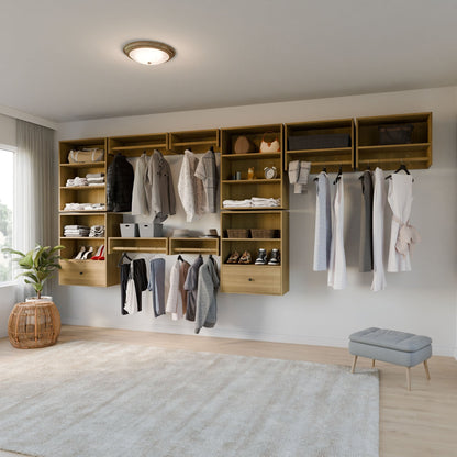 A modern Krovel Furniture Co. Closet with White Oak shelves and hanging rods holds clothes, shoes, and bags against a white wall. A soft rug covers the wooden floor near a plant in a basket and a small gray stool beside a large window. 