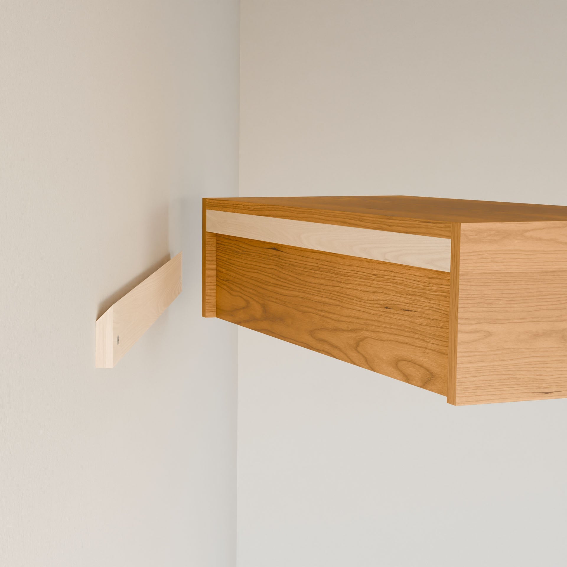 The Closet Hanger in Cherry by Krovel Furniture Co. is a handmade piece from Portland, Maine, featuring light and dark wood tones. It elegantly enhances a minimalist space with its premium-grade plywood and visible bracket for secure installation on light walls.