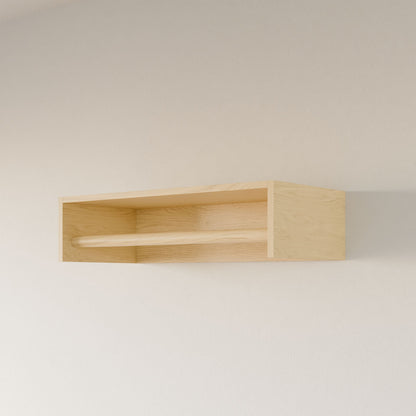 The Closet Hanger in Maple by Krovel Furniture Co. is a handmade, light-colored plywood wall shelf from Portland, Maine. It features a minimalistic design with a smooth finish and a horizontal wooden bar across the front for combined style and function, beautifully mounted on a pale wall.