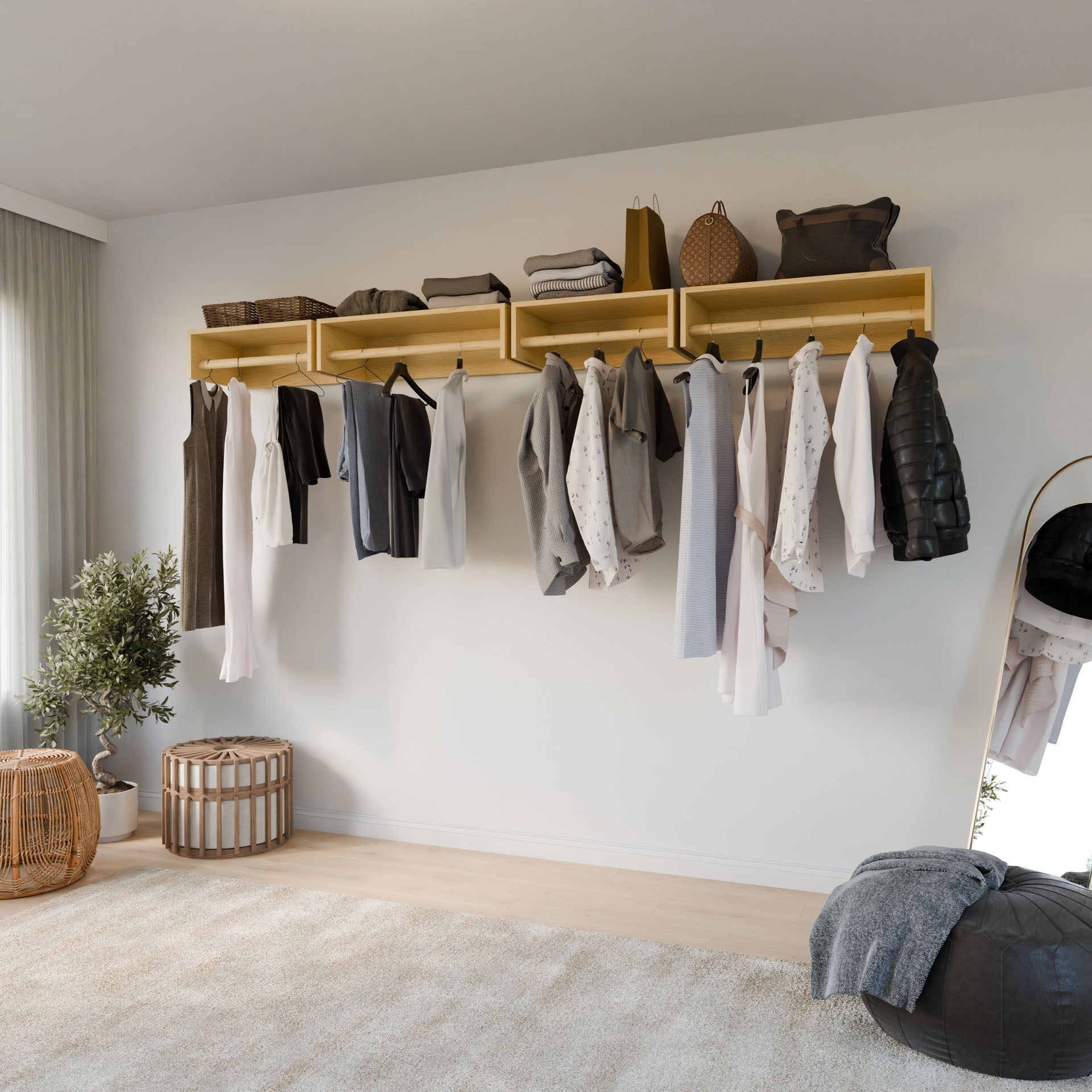 A minimalist room features a Closet Hanger in Maple by Krovel Furniture Co., showcasing shirts and jackets. A potted plant and a handmade wicker basket from Portland, Maine, sit on the carpeted floor, while a mirror reflects part of the serene space.