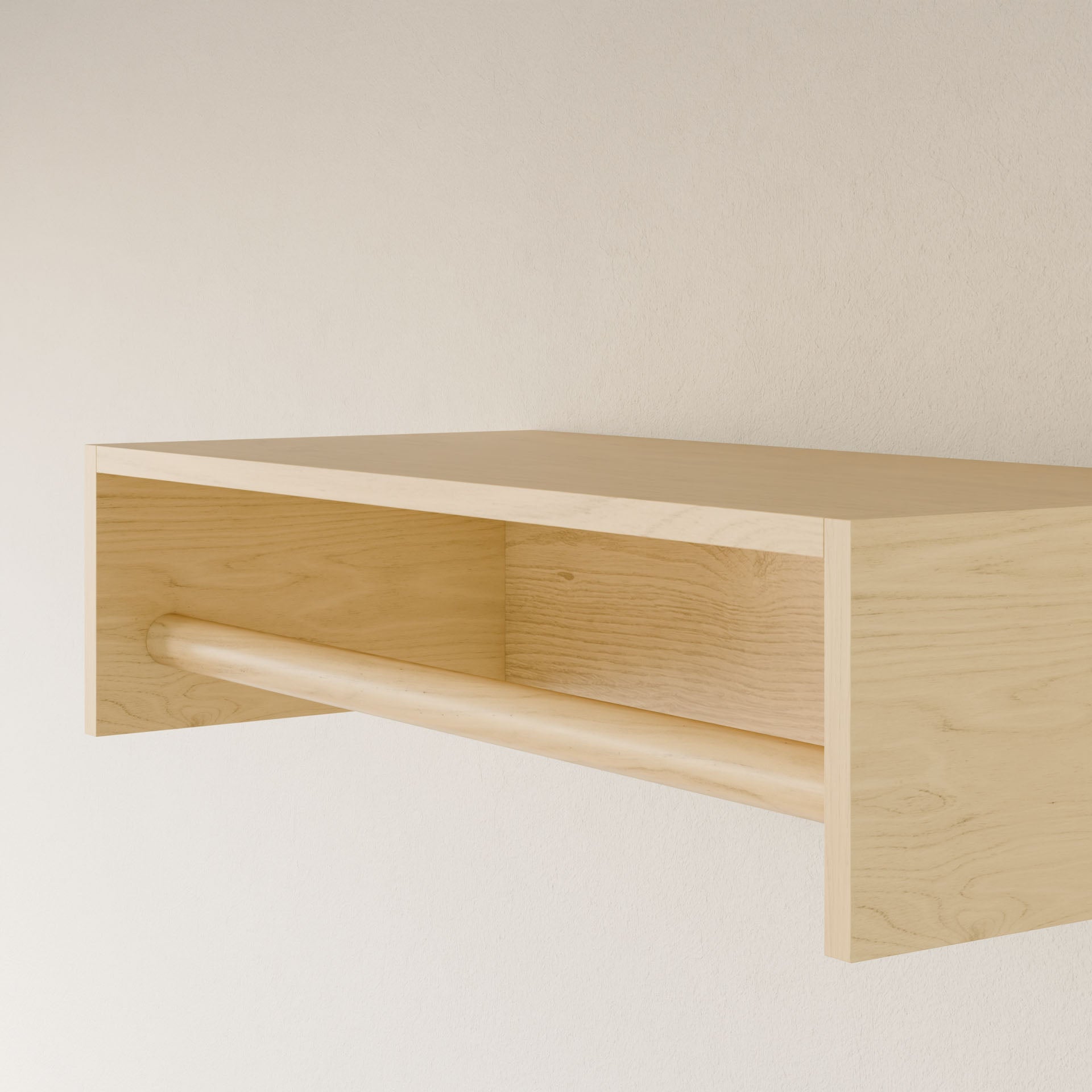 The Closet Hanger in Maple by Krovel Furniture Co. is a minimalist, handmade wooden shelf from Portland, Maine. It features a tubular bar and mounts on a plain white wall. Crafted from premium grade plywood, it boasts a simple rectangular design with smooth surfaces and a light wood finish.