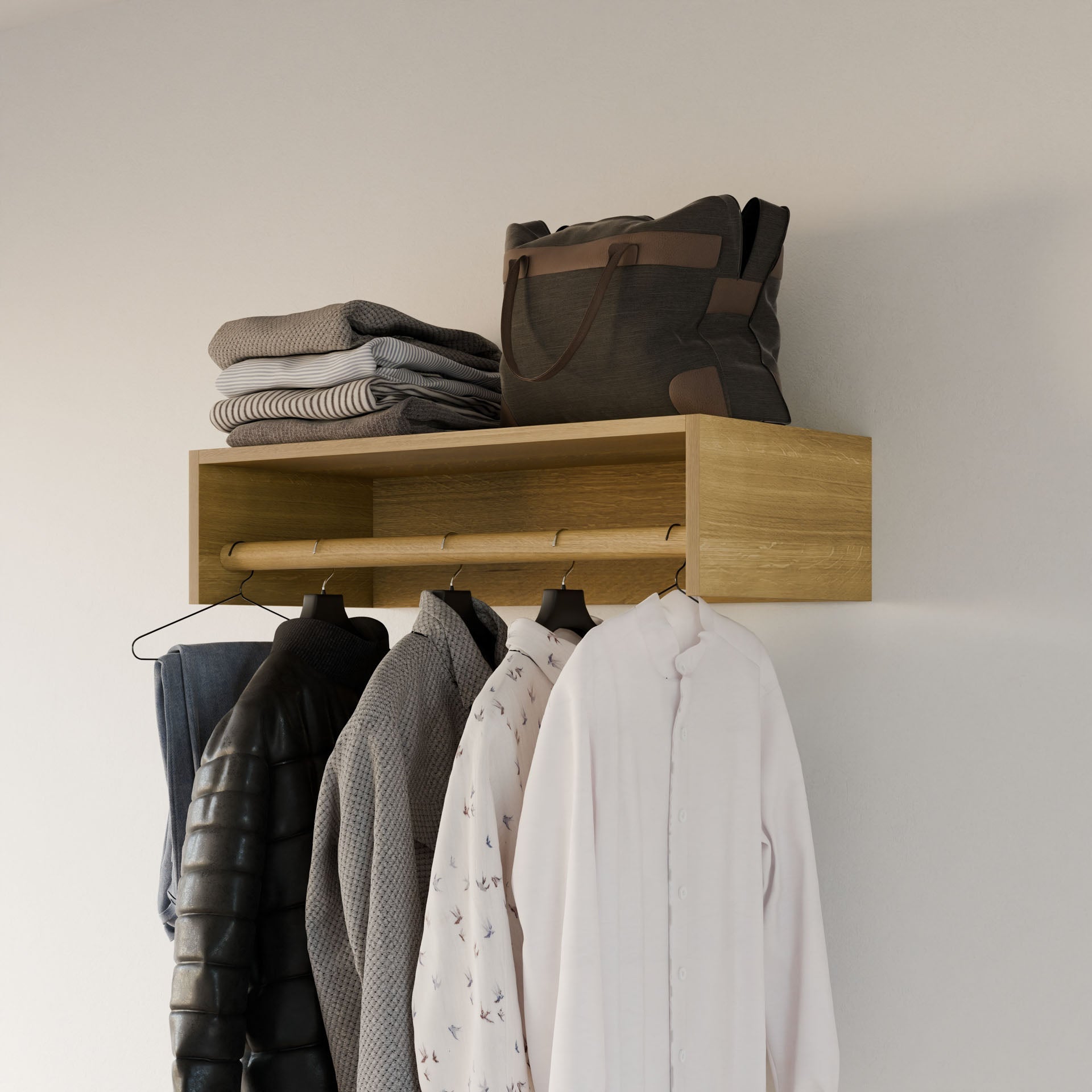 Handmade by Krovel Furniture Co. in Portland, Maine, the Closet Hanger in White Oak combines style and function with a modular design. Hang coats and shirts below while neatly placing folded sweaters and a dark bag on top against a plain wall.