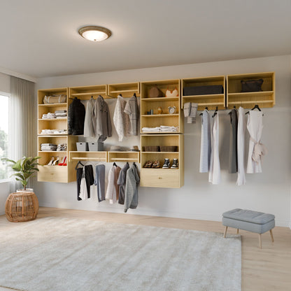 A modern bedroom closet featuring Krovel Furniture Co.'s Closet Hanger with Shelf in Maple displays neatly organized clothing, shoes, and accessories. A potted plant and wicker basket adorn the floor alongside a plush gray ottoman. A window curtain complements the space, with a ceiling light fixture overhead.