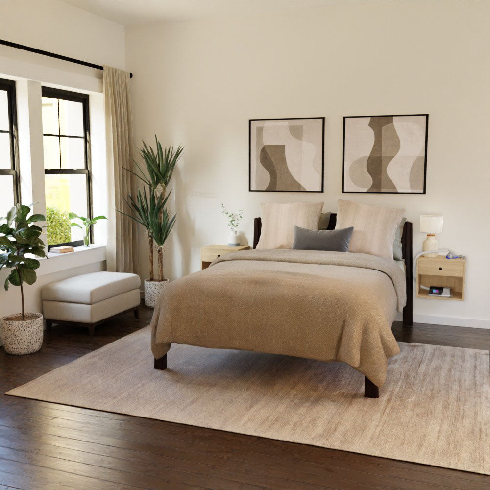 A cozy bedroom featuring a neatly made bed with beige linens exudes Mid-Century Modern charm. Two abstract artworks adorn the wall above, while a CPAP Nightstand in Maple from Krovel elegantly complements the wooden floors, large rug, potted plants, side table, and window that allows natural light to stream in.