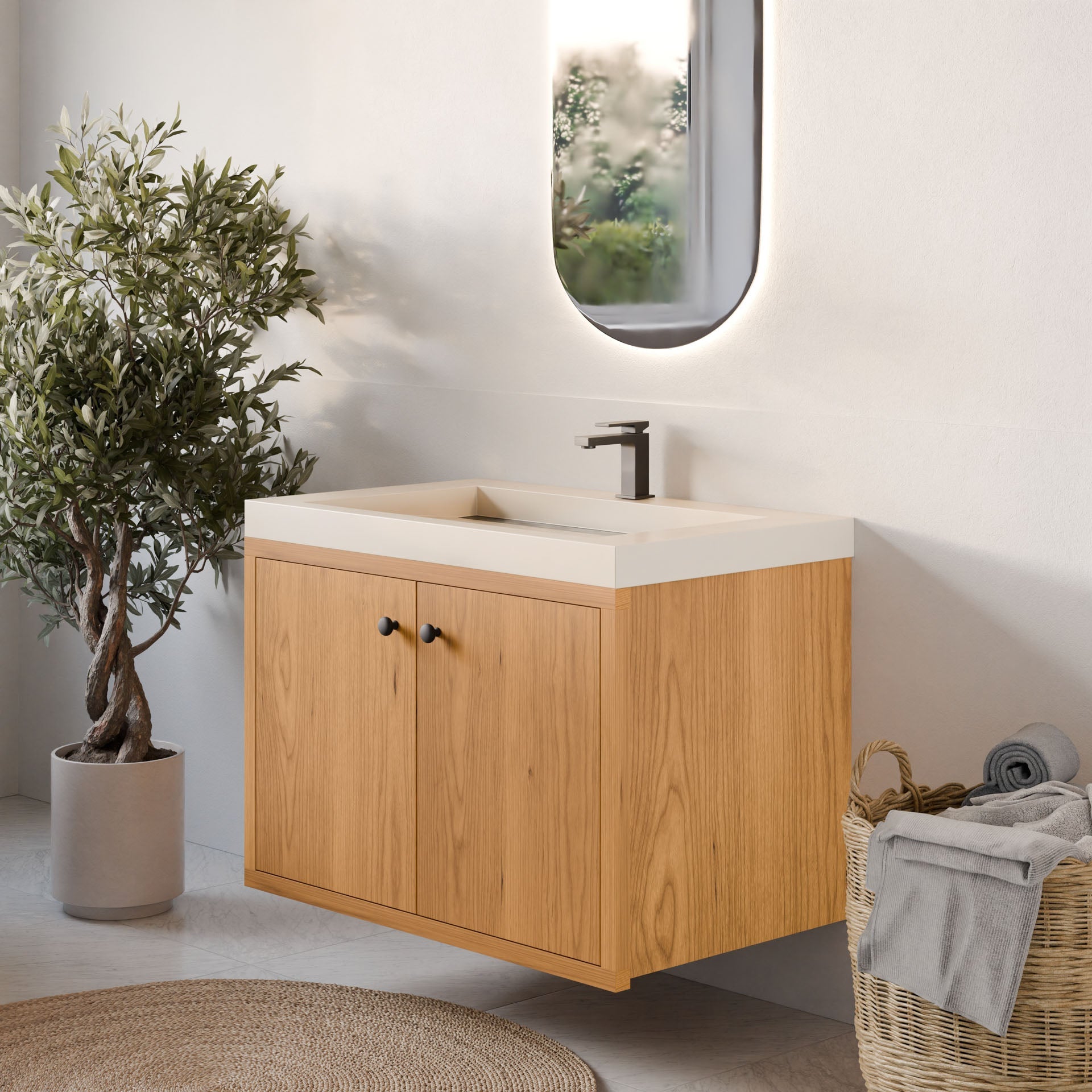 A modern bathroom features the Krovel Furniture Co.'s Double Door Vanity in Cherry with a white sink. Above it is an oval backlit mirror. A potted plant beside the vanity and rolled towels in a wicker basket on the floor enhance the serene ambiance.