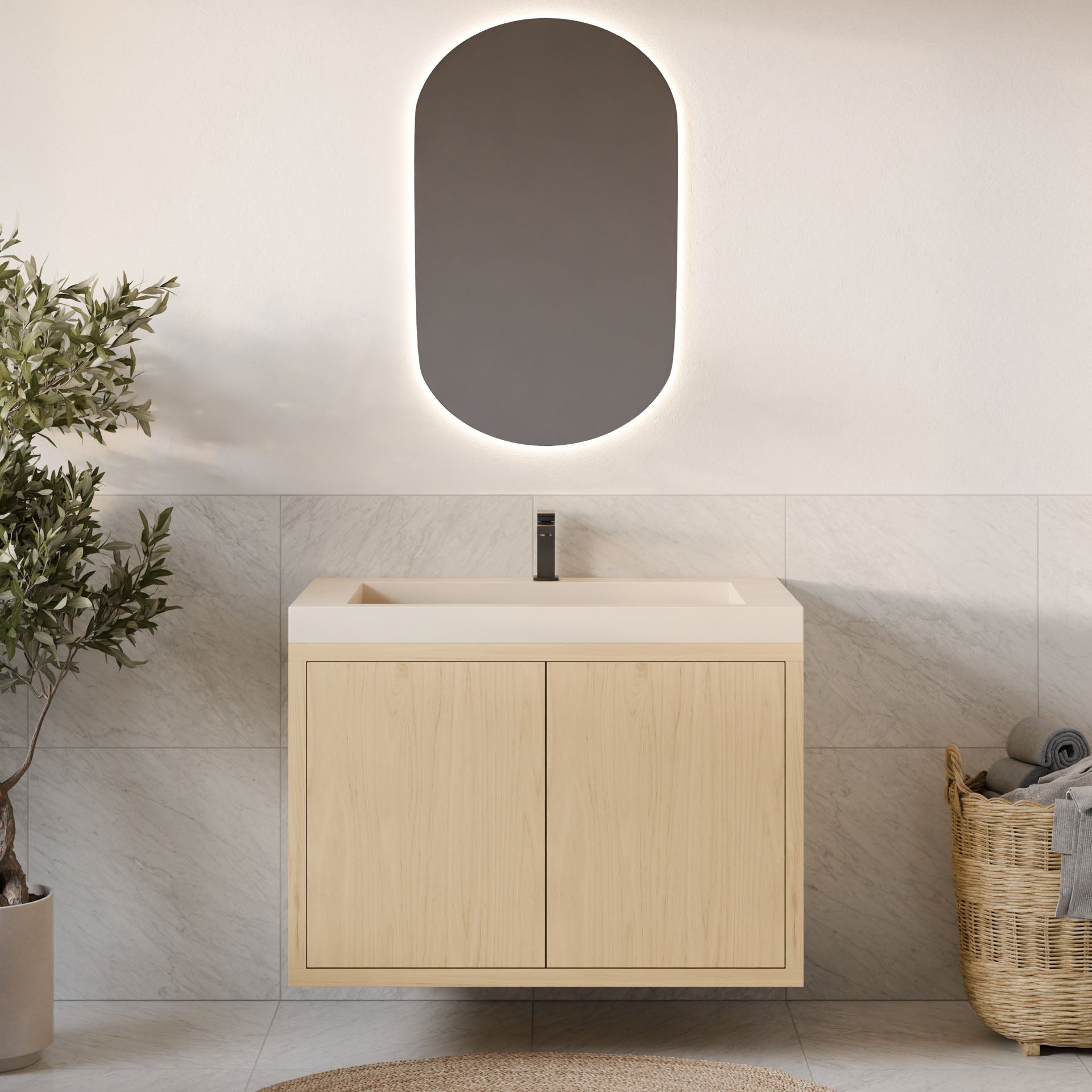 A modern bathroom showcases a Krovel Furniture Co. Double Door Vanity in Maple with an oval backlit mirror. A plant on the left and a woven towel basket on the right complement the light-tiled walls and floor, while soft-close hinges enhance its sleek, functional design.