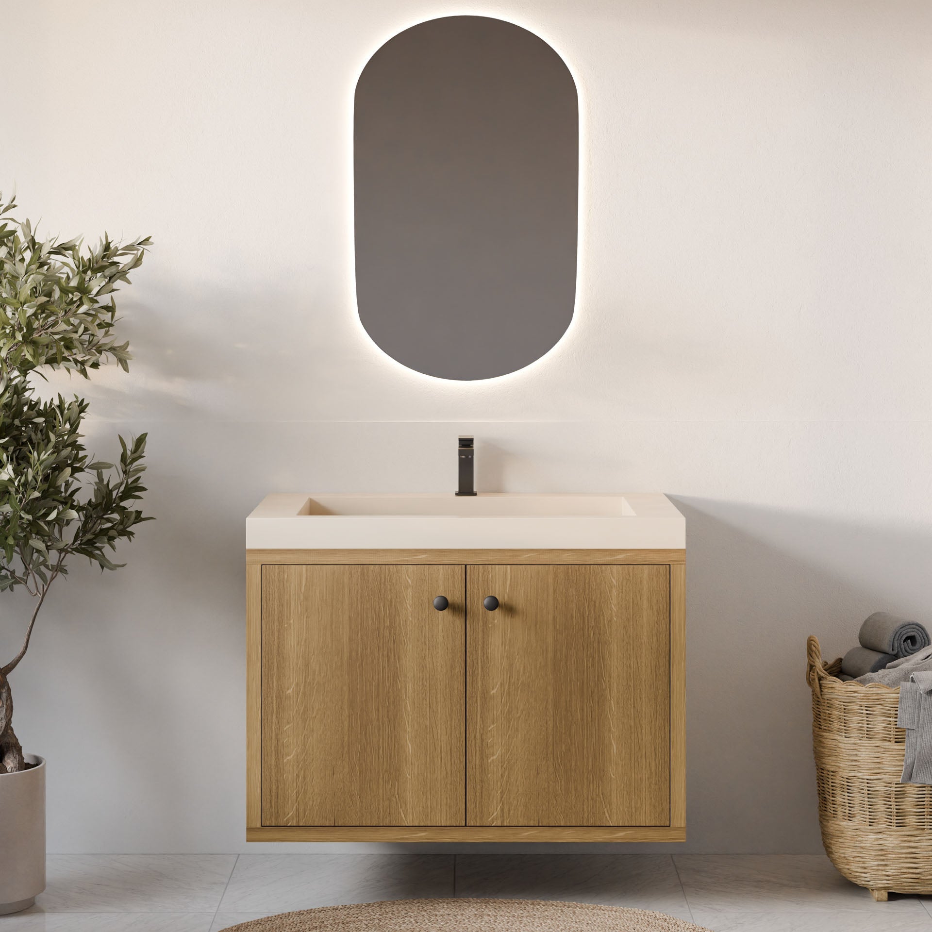 A modern bathroom showcases a Krovel Furniture Co. Double Door Vanity in White Oak with a smooth countertop and sleek faucet, topped by an oval mirror with soft lighting. A woven basket with towels and a potted plant add charm to the space.