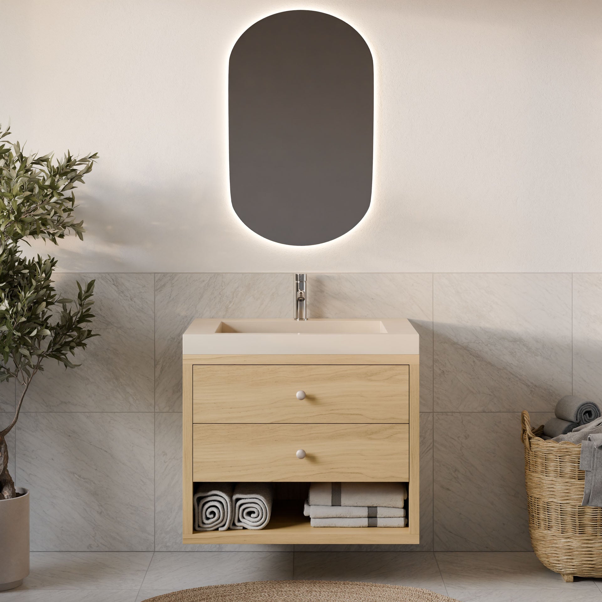 A contemporary bathroom showcases Krovel Furniture Co.'s Double Drawer, Open Shelf Vanity in Maple, accompanied by an illuminated oval mirror. To its left is a potted plant and to the right, a basket with towels. The walls are elegantly tiled.