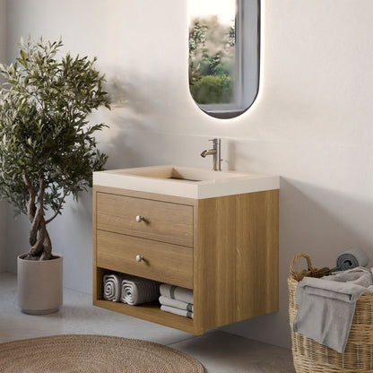 A modern bathroom features a Krovel Furniture Co. Double Drawer, Open Shelf Vanity in White Oak with an oval mirror above. Two drawers and an open shelf hold rolled towels, while a potted plant and wicker basket enhance the charm. Soft lighting adds to the serene atmosphere.