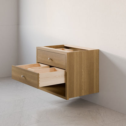 The Double Drawer, Open Shelf Vanity in White Oak by Krovel Furniture Co. is a modern, wall-mounted floating vanity with a hardwood veneer finish and two open drawers. This elegant piece highlights natural wood beauty with metal knobs and offers custom sizes to complement any light-colored wall and tiled floor.