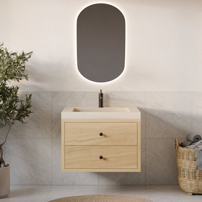 A modern bathroom features Krovel Furniture Co.'s Double Drawer Vanity in Maple with dovetail joinery under a sleek sink. An oval backlit mirror adds elegance, while a wicker basket with towels and a potted plant rest on the light tile floor.