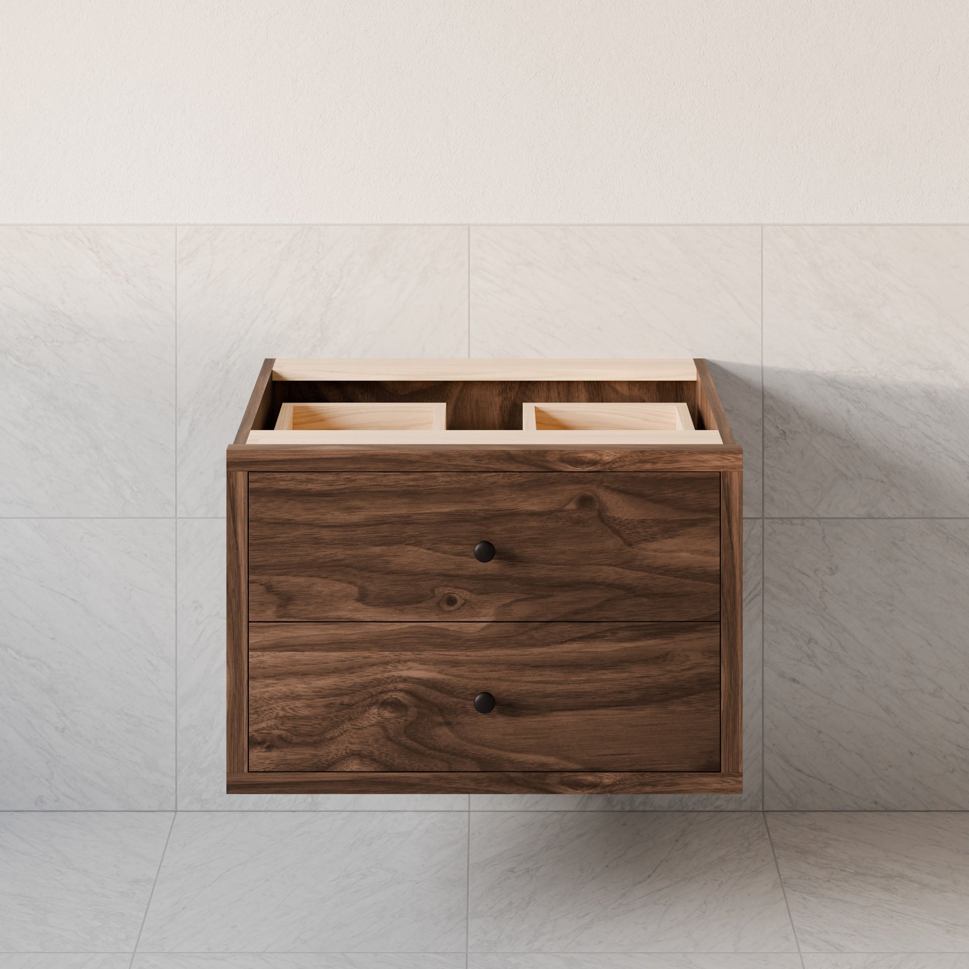 The Double Drawer Vanity in Walnut by Krovel Furniture Co. is a wall-mounted, floating vanity with two drawers and two top open compartments. It features a natural hardwood veneer finish and round black knobs, set against a light gray tiled background, and offers customizable sizing options.