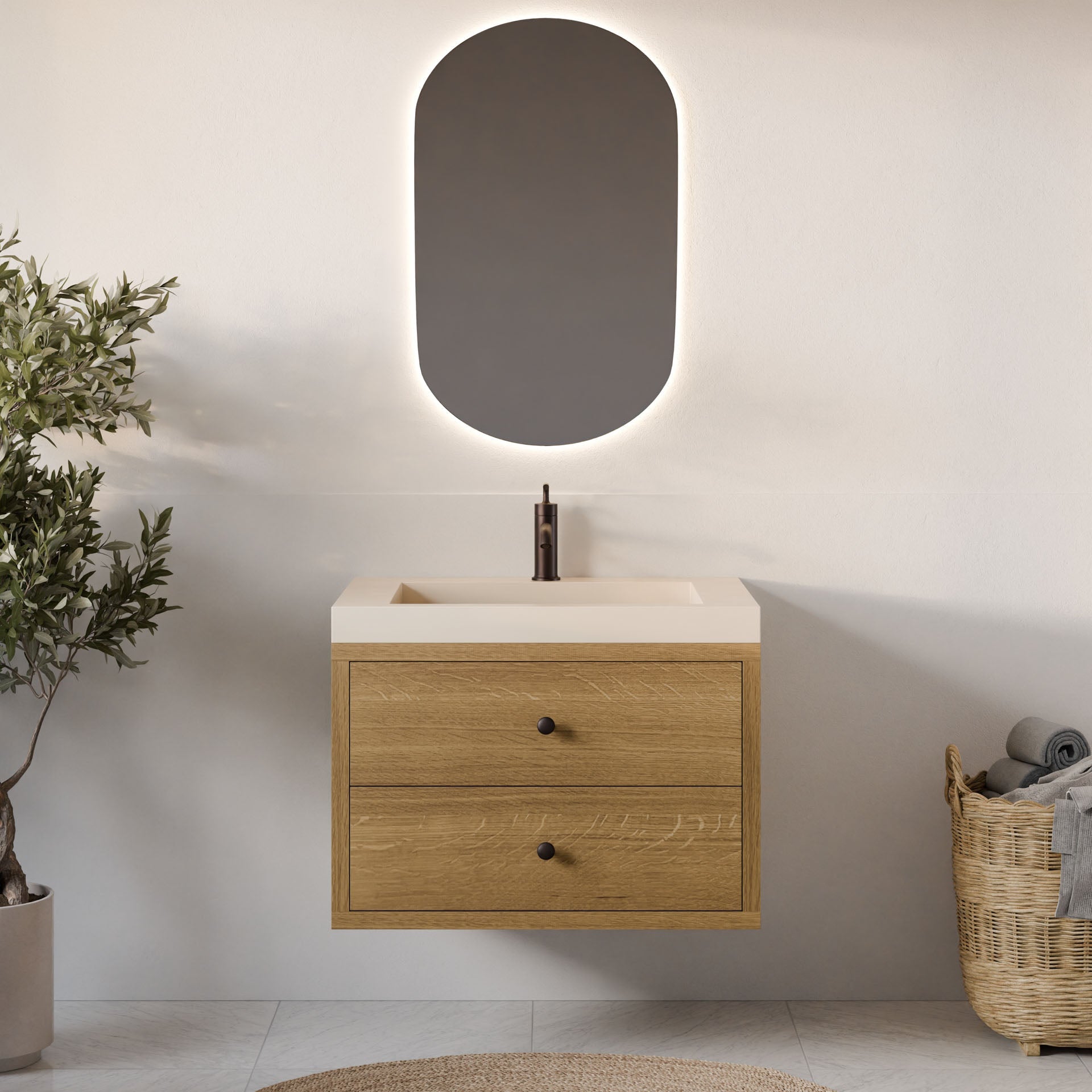 A modern bathroom features a Krovel Furniture Co. Double Drawer Vanity in White Oak, equipped with soft-close drawers below a white rectangular basin, paired with a black faucet. An oval backlit mirror hangs above, complemented by a wicker basket of towels and a potted plant.