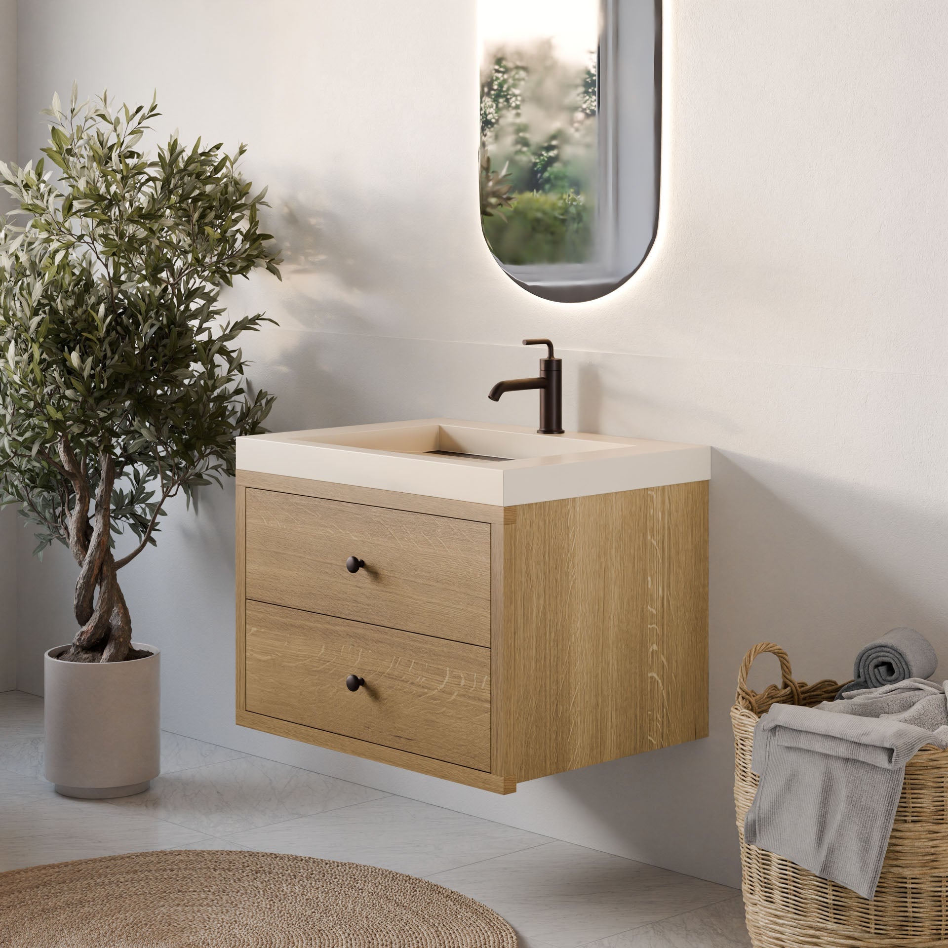 A modern bathroom features a Krovel Furniture Co. Double Drawer Vanity in White Oak with soft-close drawers and a white countertop. Above it, an oval mirror complements the sleek black faucet, while charm is added by a potted plant and wicker basket with towels.