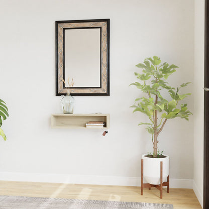 A minimalist living space with an American White Oak floor features a decorative mirror above a small wooden shelf on a white wall. To the right, a potted plant with green leaves is elevated on the Entryway Organizer in Maple by Krovel, mounted using a French-cleat system.