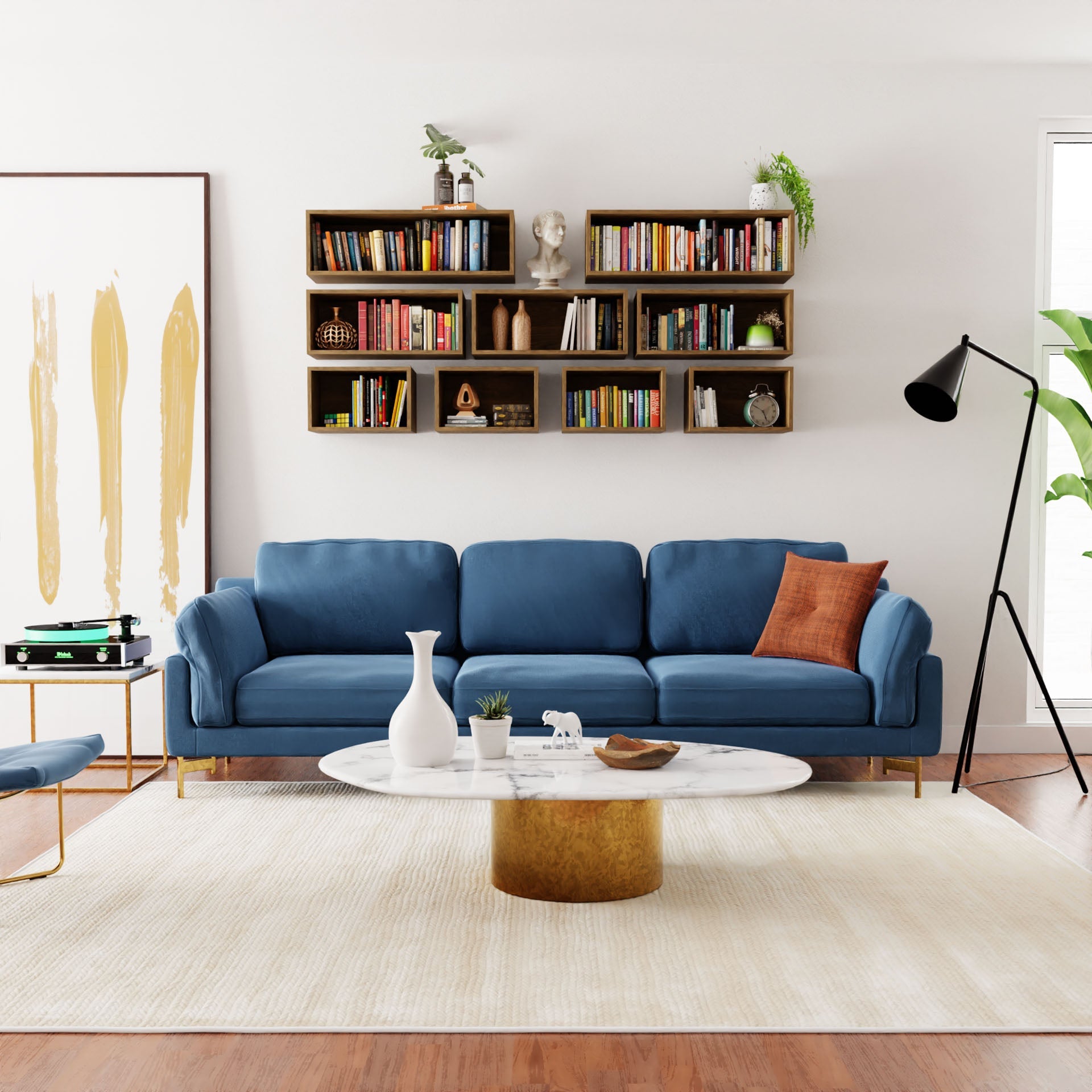 A modern living room showcases a handmade blue sofa, marble coffee table, and large abstract painting. Krovel's Floating Bookshelf in White Oak is mounted on the wall, with a floor lamp and plant in the corner, complementing the wooden floor and pristine white walls.