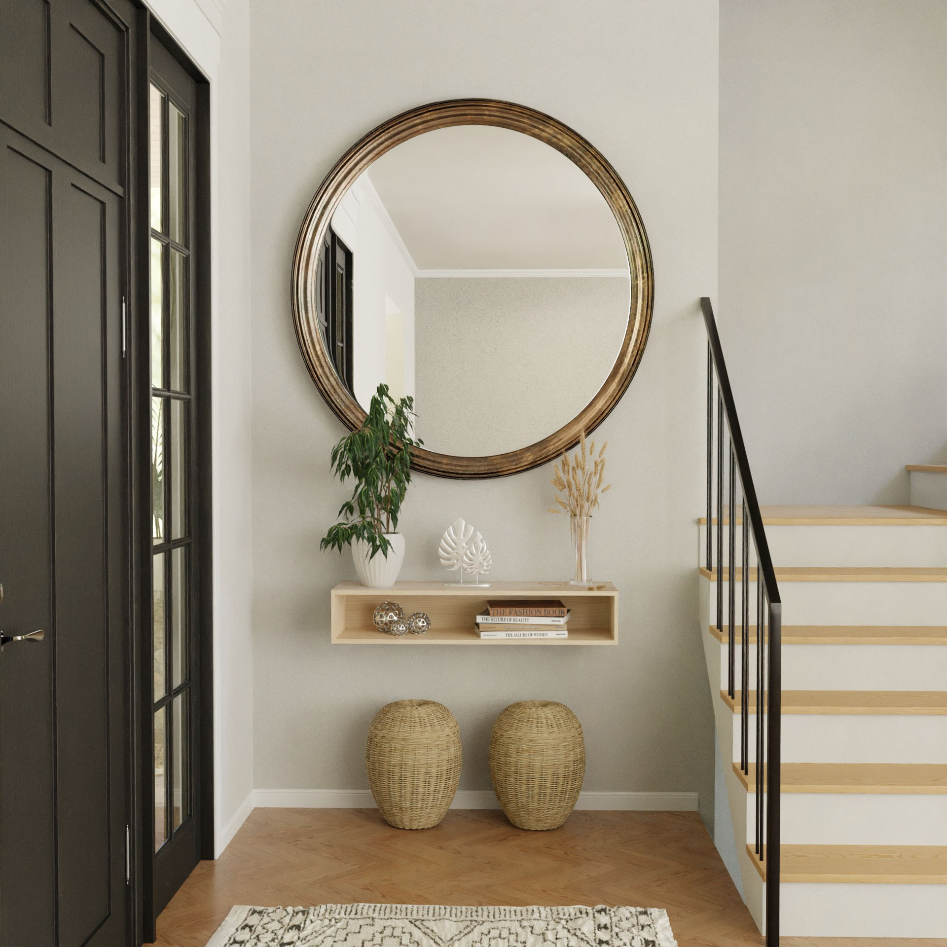 A minimalist entryway features a large round mirror above the Krovel Floating Console Table in Maple, adorned with plants and decor. Two woven baskets rest below. The area is highlighted by a staircase with a black handrail and a dark door on the left.