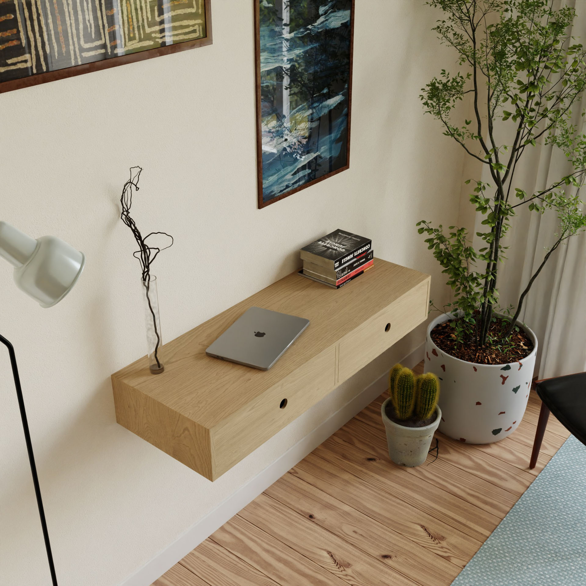 In a minimalist room, a sophisticated Krovel Floating Desk in Maple holds a laptop, books, and twigs in a vase. A large potted plant and small cactus rest on the wooden floor. Framed art and a white lamp are elegantly mounted on the light-colored wall.