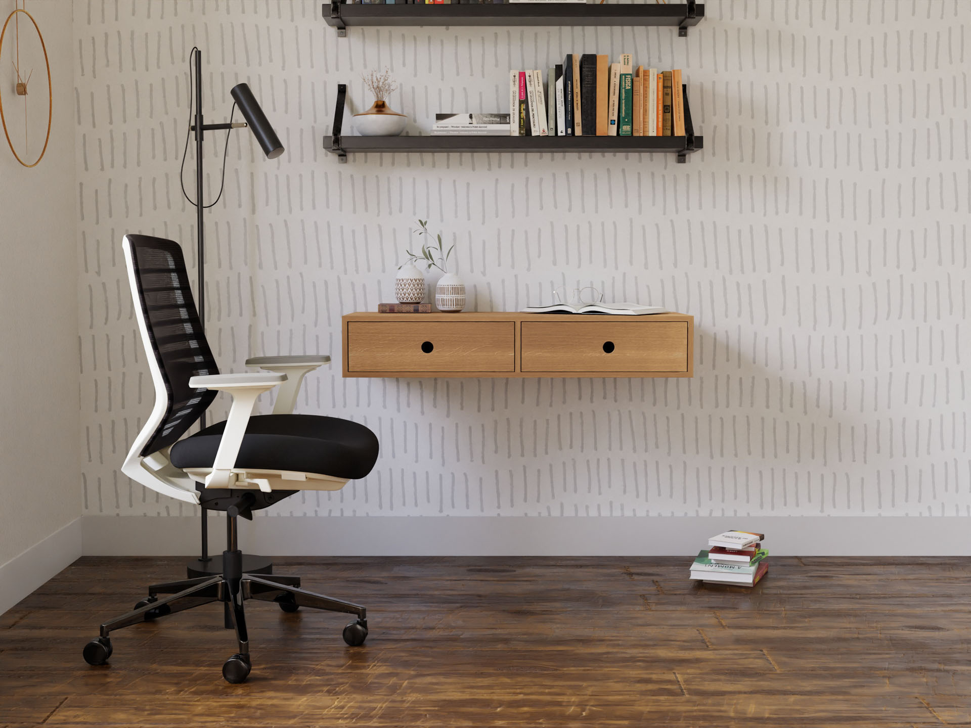 A minimalist home office showcases a handmade black and white ergonomic chair, a Krovel Floating Desk in White Oak with two drawers, and a wall lamp. Two shelves above display books and decor items. The room features a patterned wall and wood flooring.