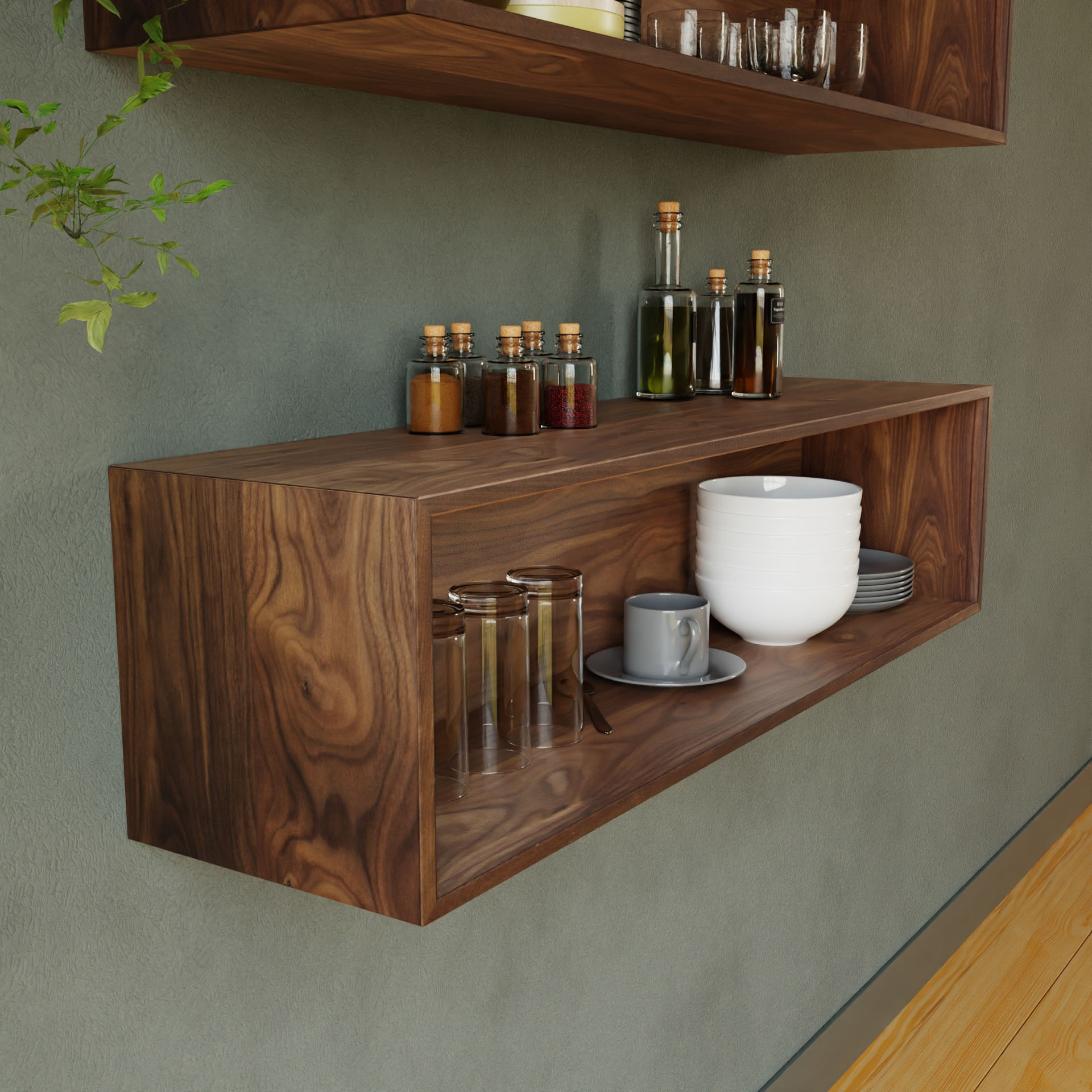 The Krovel Floating Display Case in Walnut is mounted on a green wall, showcasing neatly stacked bowls and plates, a mug, jars with cork lids containing spices or liquids, upside-down glassware, and a partially visible plant in the corner.