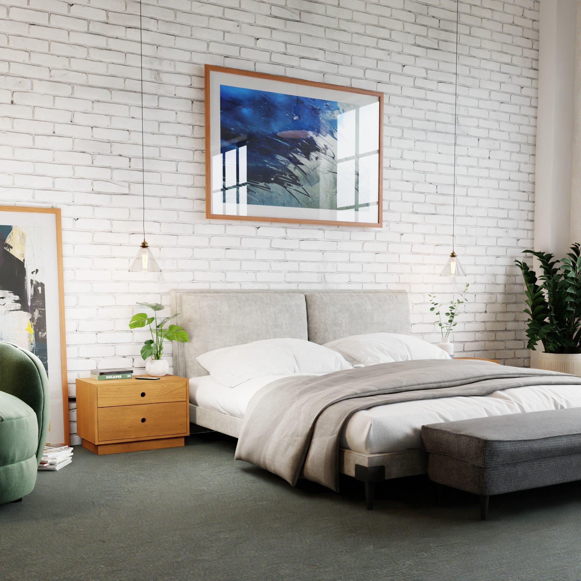 A modern bedroom with a white brick wall showcases a spacious bed with a padded headboard, complemented by gray bedding and a matching gray bench. Two pendant lights are suspended above the Freestanding Nightstands in Cherry by Krovel. A potted plant and abstract artwork enhance the decor, adding elegance to the solid hardwood furniture ensemble.