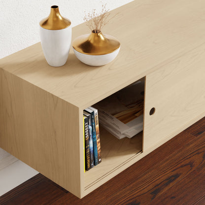 A sleek Oversized Media Console Table in Maple by Krovel showcases an open shelf filled with books and magazines. Atop the console, two decorative vases are displayed: one is tall with gold and white hues, while the other is smaller with dried flowers. The flooring complements the setup with its rich dark wood tones.