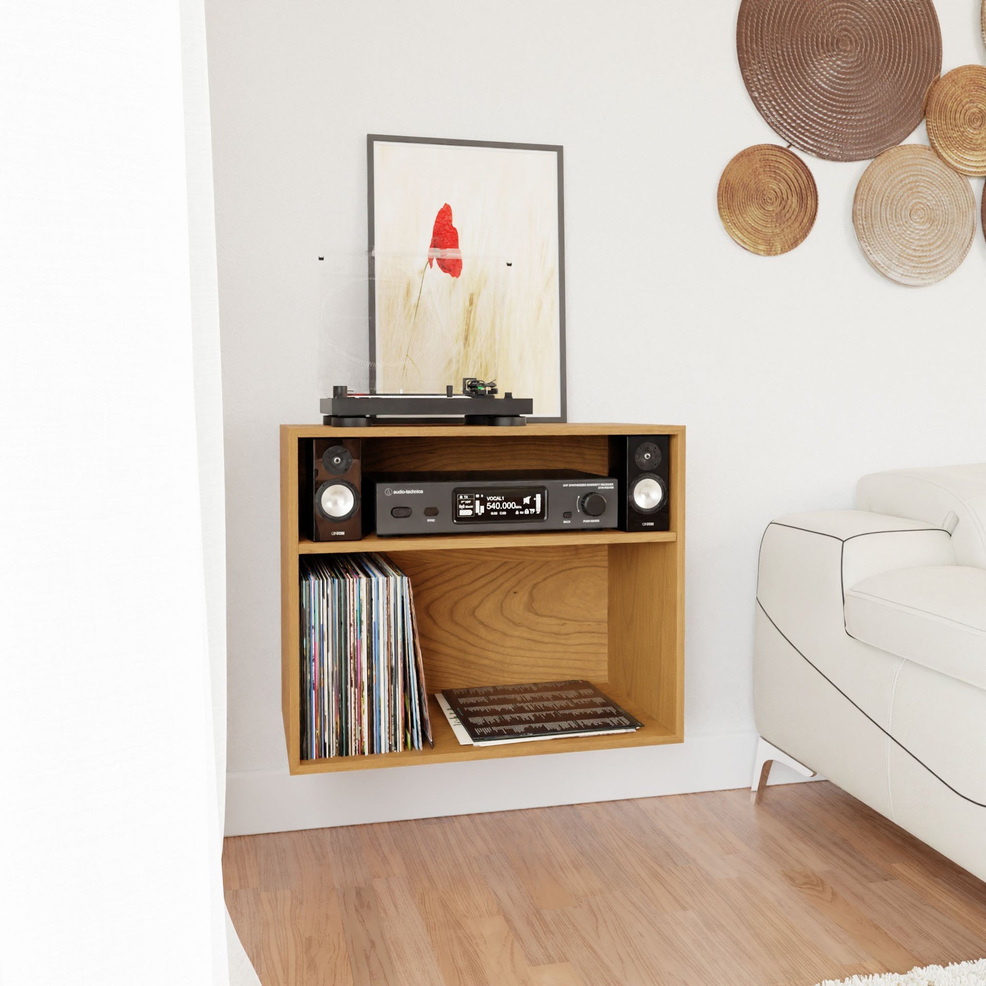 A modern living room corner showcases the Krovel Record and Stereo Storage Cabinet in Cherry, which holds vinyl records, a record player, and audio equipment. A framed abstract art piece with a red figure adds flair above the Mid-Century Modern sofa, complemented by decorative round wicker elements on the wall.