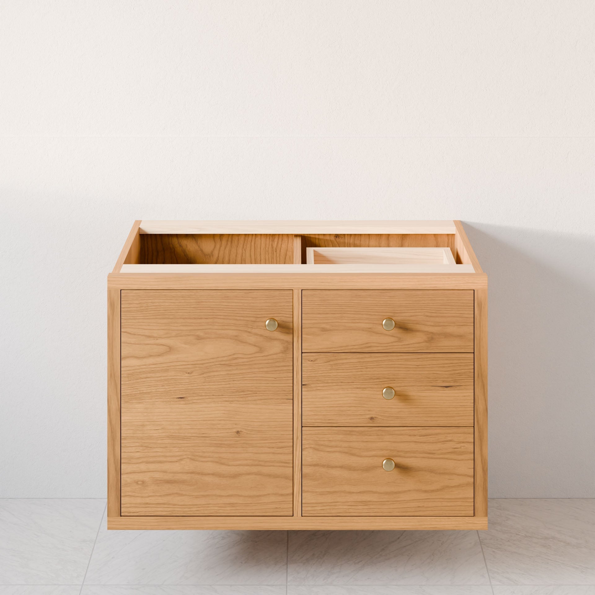 The Krovel Furniture Co. "Single Door, Triple Drawer Vanity in Cherry" is a minimalist floating design in hardwood veneer with one door and three soft-close drawers adorned with small round handles, set against a light-colored wall. The missing countertop leaves an empty top section.