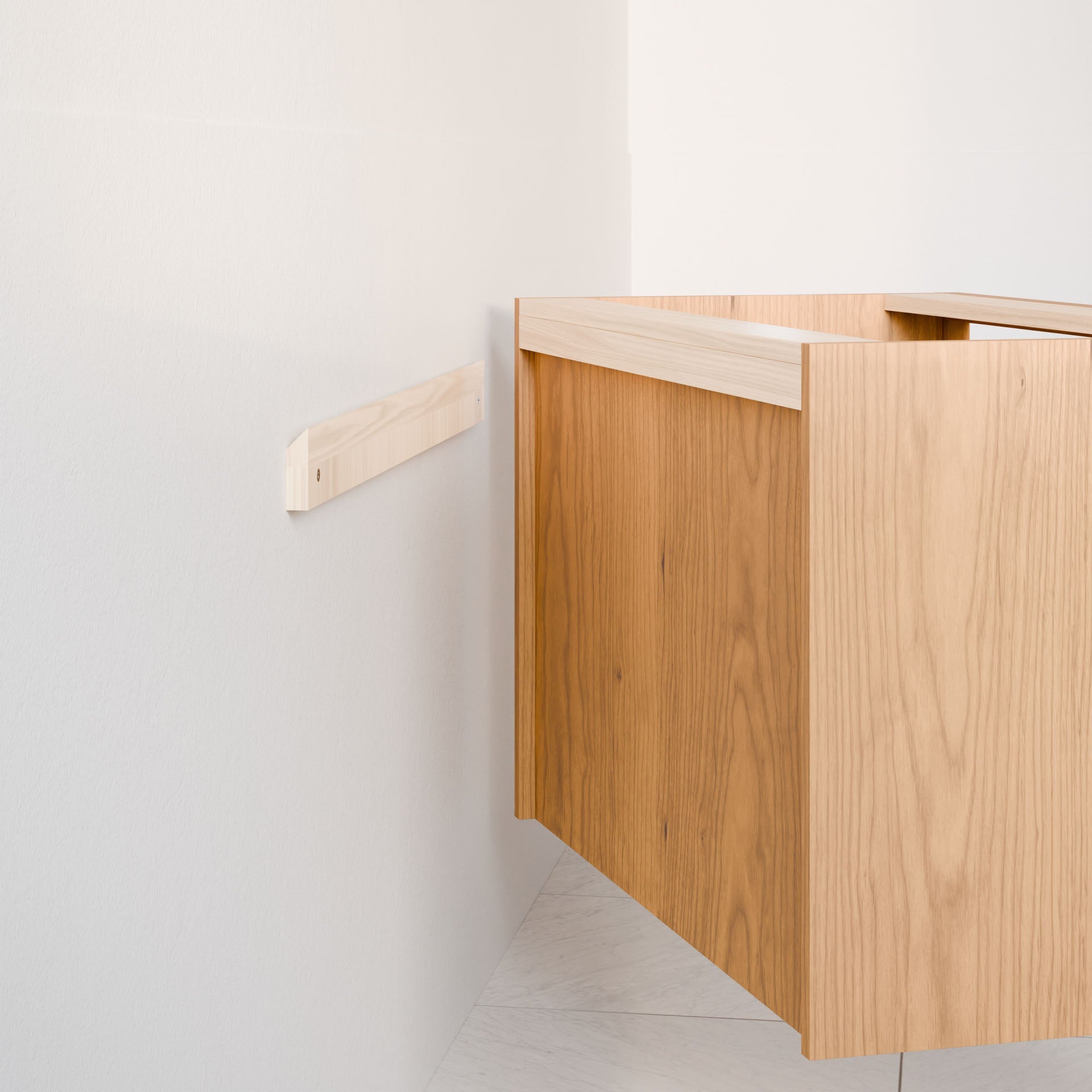 A wooden vanity in a natural cherry finish is partially installed against a white wall, showcasing a sleek hardwood veneer. The Krovel Furniture Co. Single Door, Triple Drawer Vanity design floats slightly away from the wall, revealing the mounting mechanism and soft-close drawers.