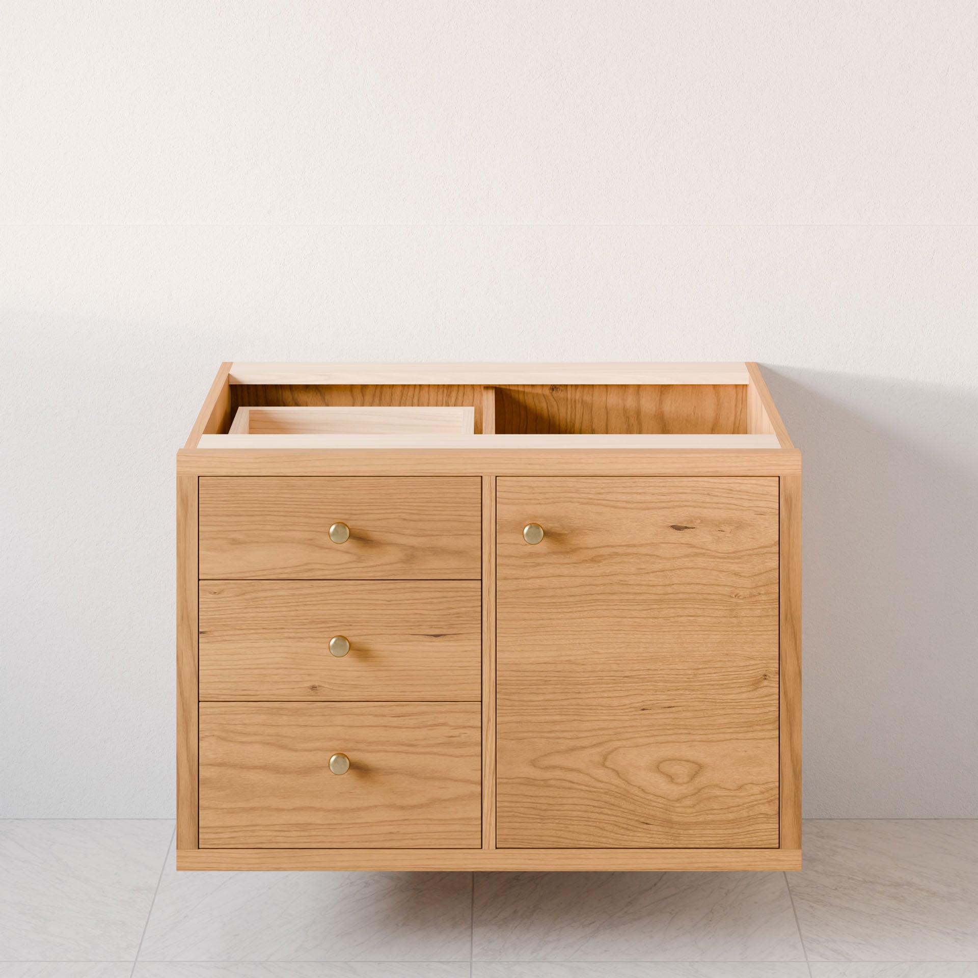 Krovel Furniture Co.'s Single Door, Triple Drawer Vanity in Cherry, with a light natural finish, is placed against a white wall. It features three soft-close drawers on the left and a cabinet door on the right with round metal knobs, revealing its hardwood veneer interior.