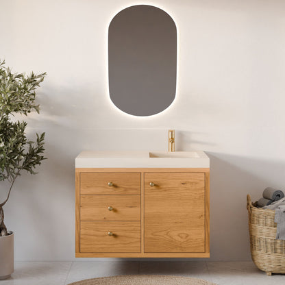 A modern bathroom features a wall-mounted Krovel Furniture Co. Single Door, Triple Drawer Vanity in Cherry with a single sink. An oval backlit mirror hangs above, complemented by a woven basket of towels and a potted plant for natural accents.