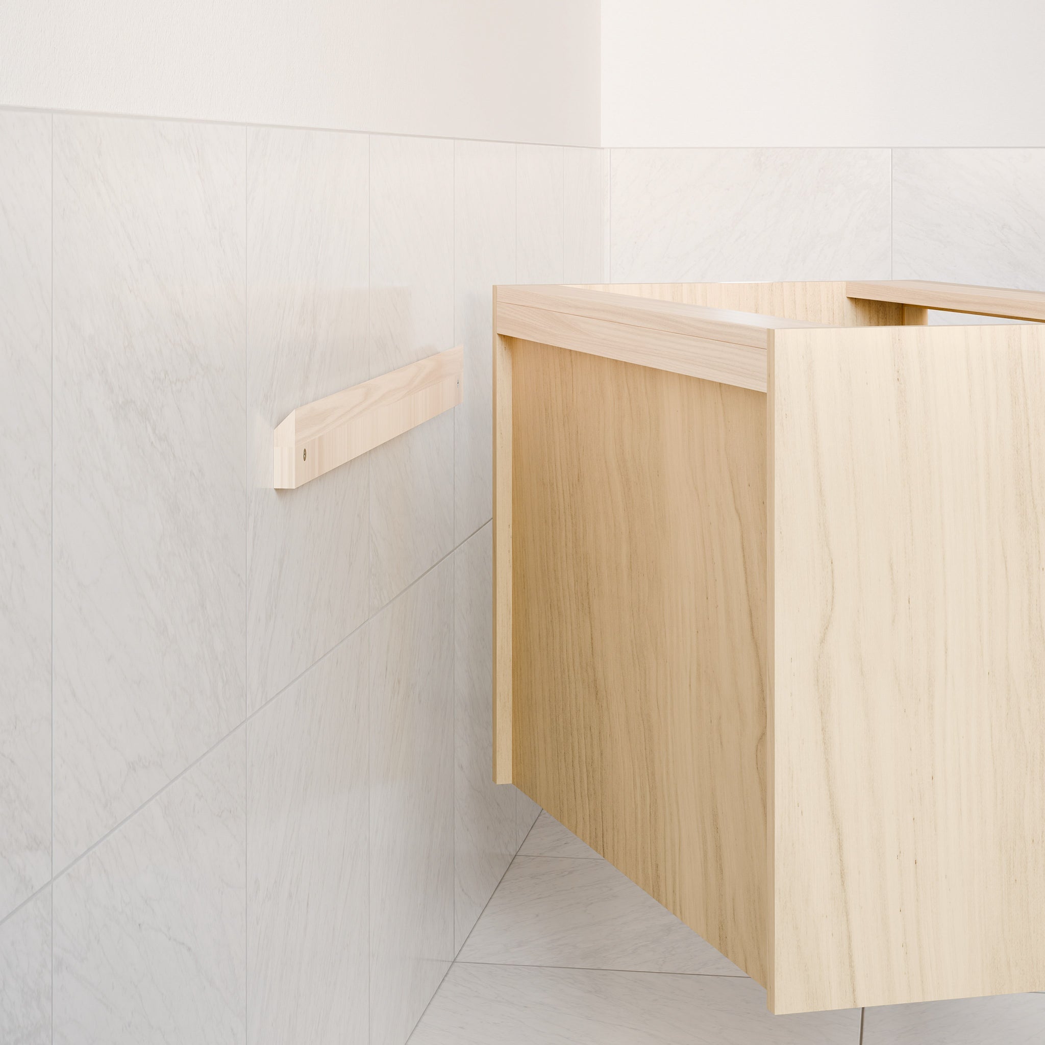 A minimalist bathroom features the "Single Door, Triple Drawer Vanity in Maple" by Krovel Furniture Co., set in a corner against white marble tiles. The light wood vanity, crafted from maple with soft-close drawers, is complemented by a wooden towel rack on the left wall.