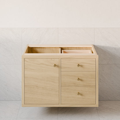 The Single Door, Triple Drawer Vanity in Maple by Krovel Furniture Co. is set against a tiled wall, offering two doors and three soft-close drawers with round knobs, topped with an open space for a sink.