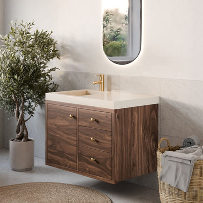 Modern bathroom with a Single Door, Triple Drawer Vanity in Walnut by Krovel Furniture Co. showcasing hardwood veneer and gold handles. A gold faucet complements the cream countertop, with an oval mirror above the sink. Soft-close hinges enhance elegance, alongside a potted plant and towel basket.