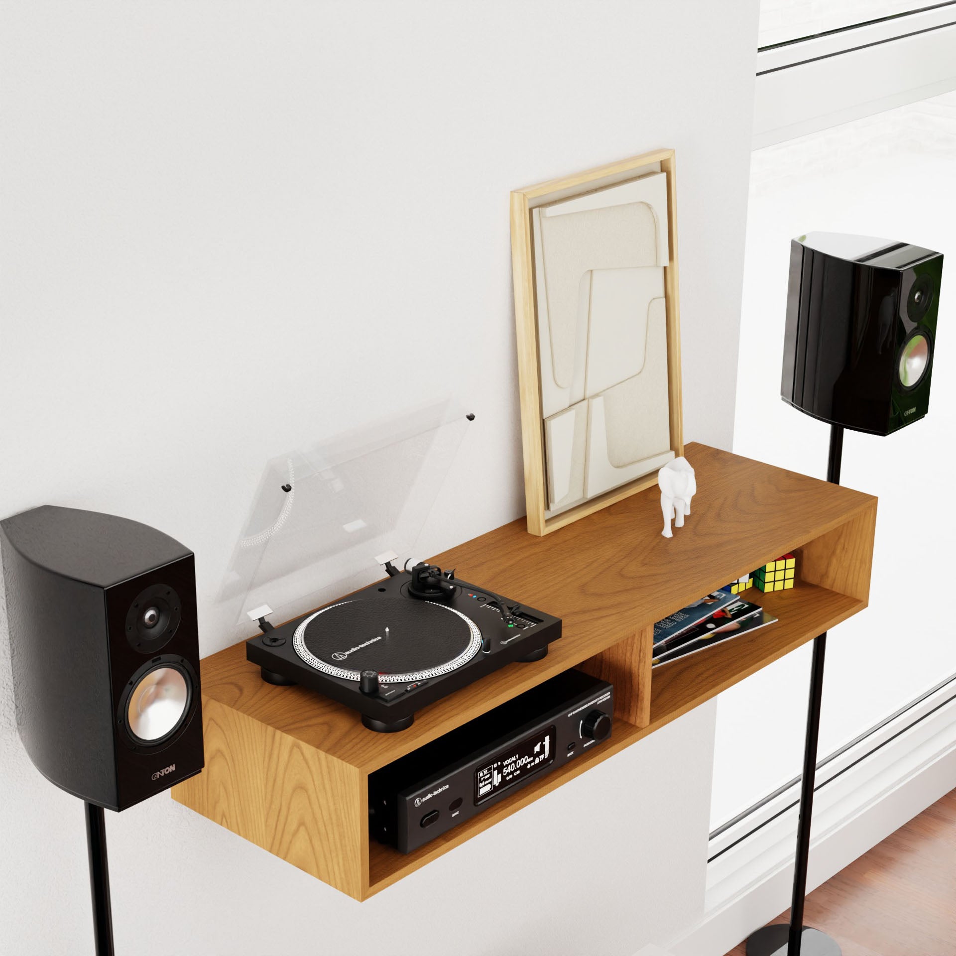 A modern living room setup showcases the Krovel Stereo Table in Cherry supporting a turntable, an amplifier, and two black speakers on stands. A framed abstract art piece, a small white figurine, and a Rubik's Cube complete the sleek mid-century modern arrangement against a white wall.