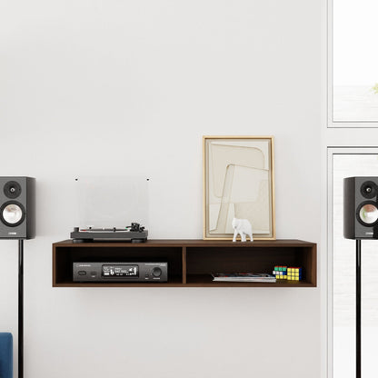 A minimalist room showcases a Krovel Stereo Table in Walnut, elegantly supporting a turntable, framed abstract artwork, and a small decorative white elephant. Two modern speakers are positioned on each side of the table. A Rubik's cube introduces a burst of color to the scene. Large windows invite natural light, creating a mid-century modern ambiance.